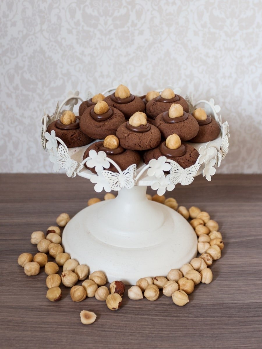 Nutellotti cookies with hazelnuts on a white serving plate.