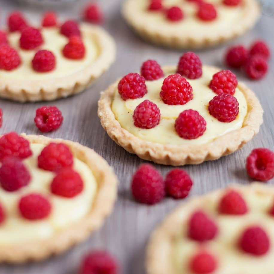 Home-made custard tarts decorated with freshly picked raspberries