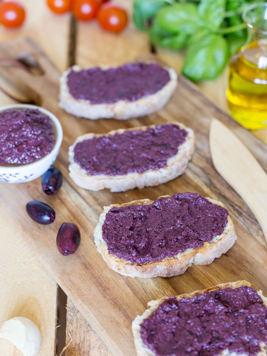 Black olive paté, or black olive paste, spread on bread is one of those lovely alternatives to the classic garlic and tomato bruchetta topping.