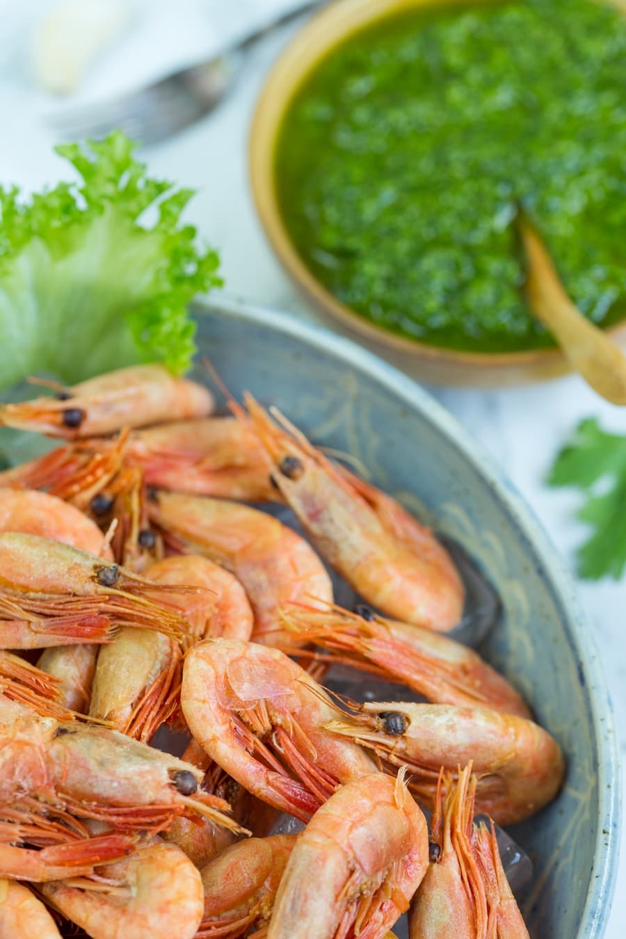 A small bowl with nordic pesto and a large bowl filled with smoked shrimp.