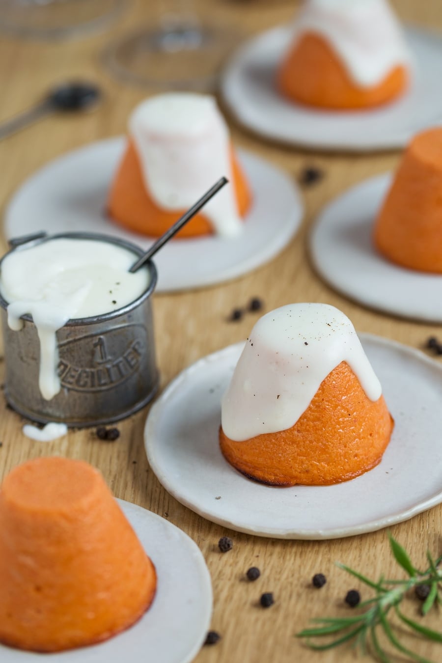 Roasted pepper flan with pecorino sauce on a white plate.