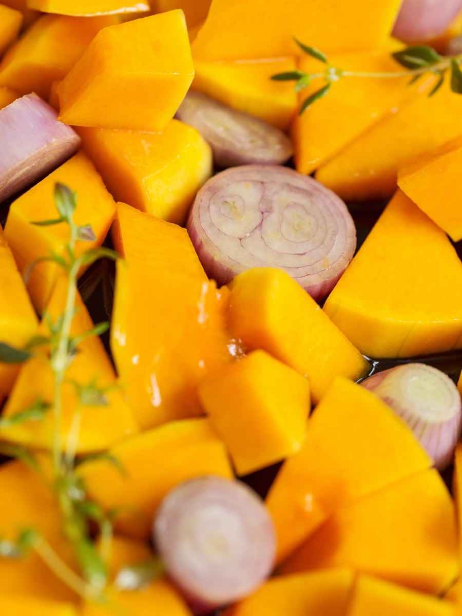 Butternut squash and shallot pieces in a loaf pan.