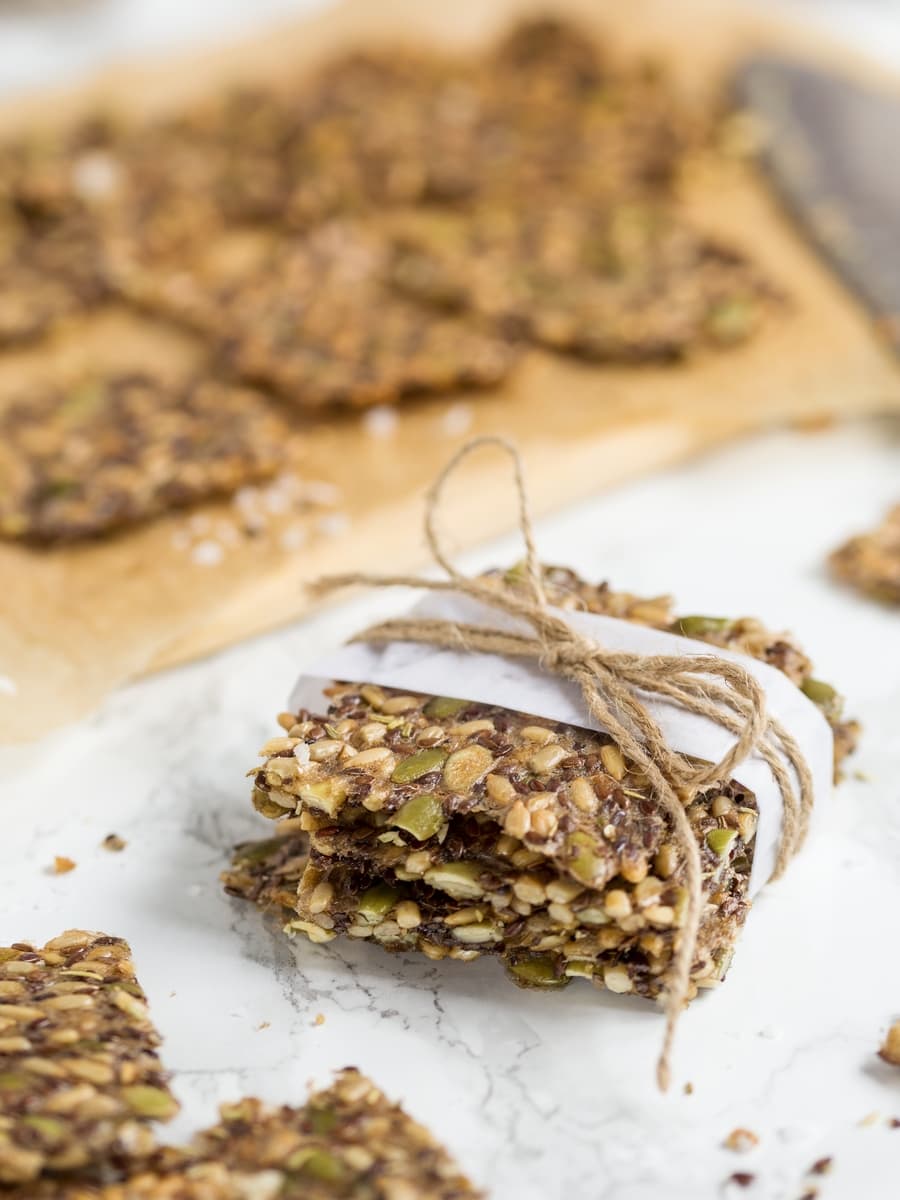 Seed crackers stacked and wrapped in white paper.