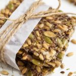 Homemade seed crackers, wrapped with white paper and jute twine.