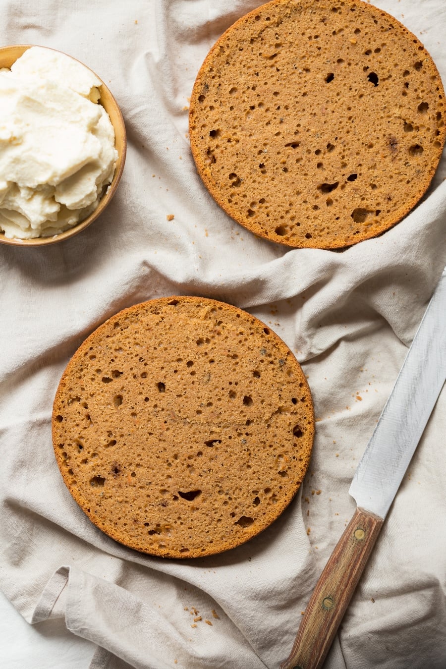 Sweet potato cake sliced up to be frosted, frosting on the side.