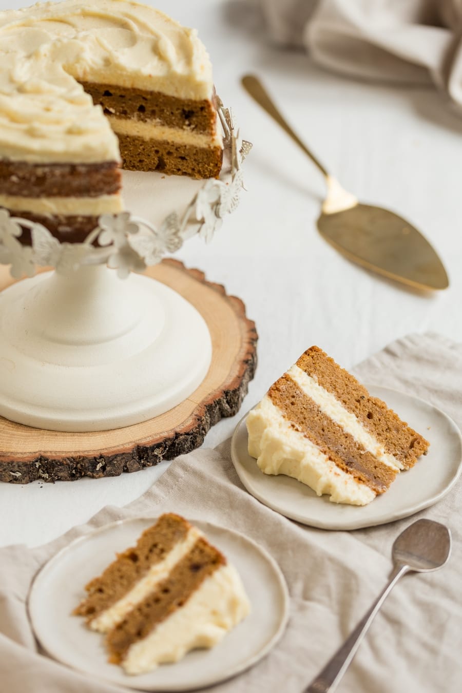 Sliced frosted cake, plated slices on the side.