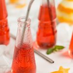 Campari soda bottle with metal straw in.