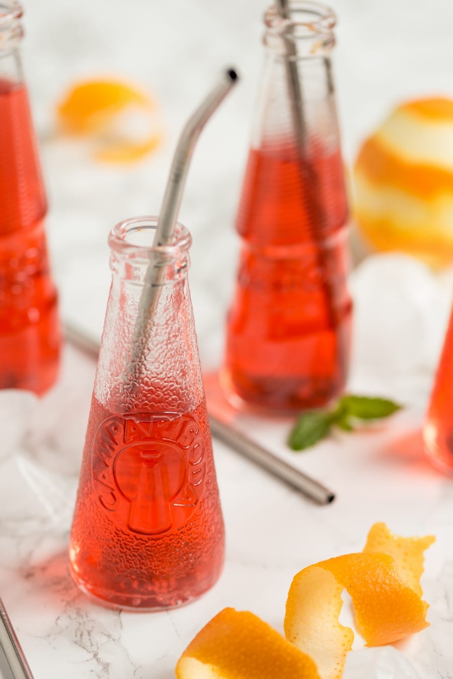 Campari soda bottle with metal straw in.