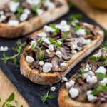 Closeup of garlicky mushroom crostini with crumbed goat cheese.