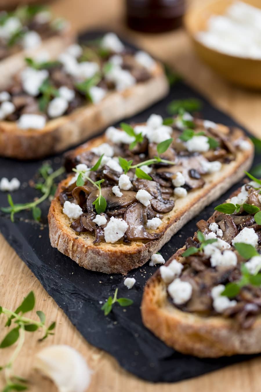 Closeup of garlicky mushroom crostini with crumbed goat cheese.