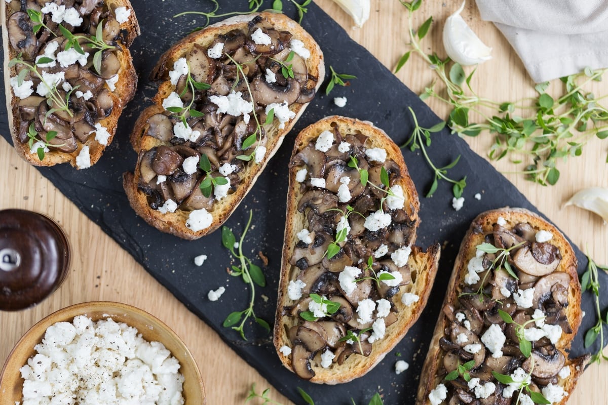 Garlicky mushroom crostini with crumbed goat cheese flat lay.
