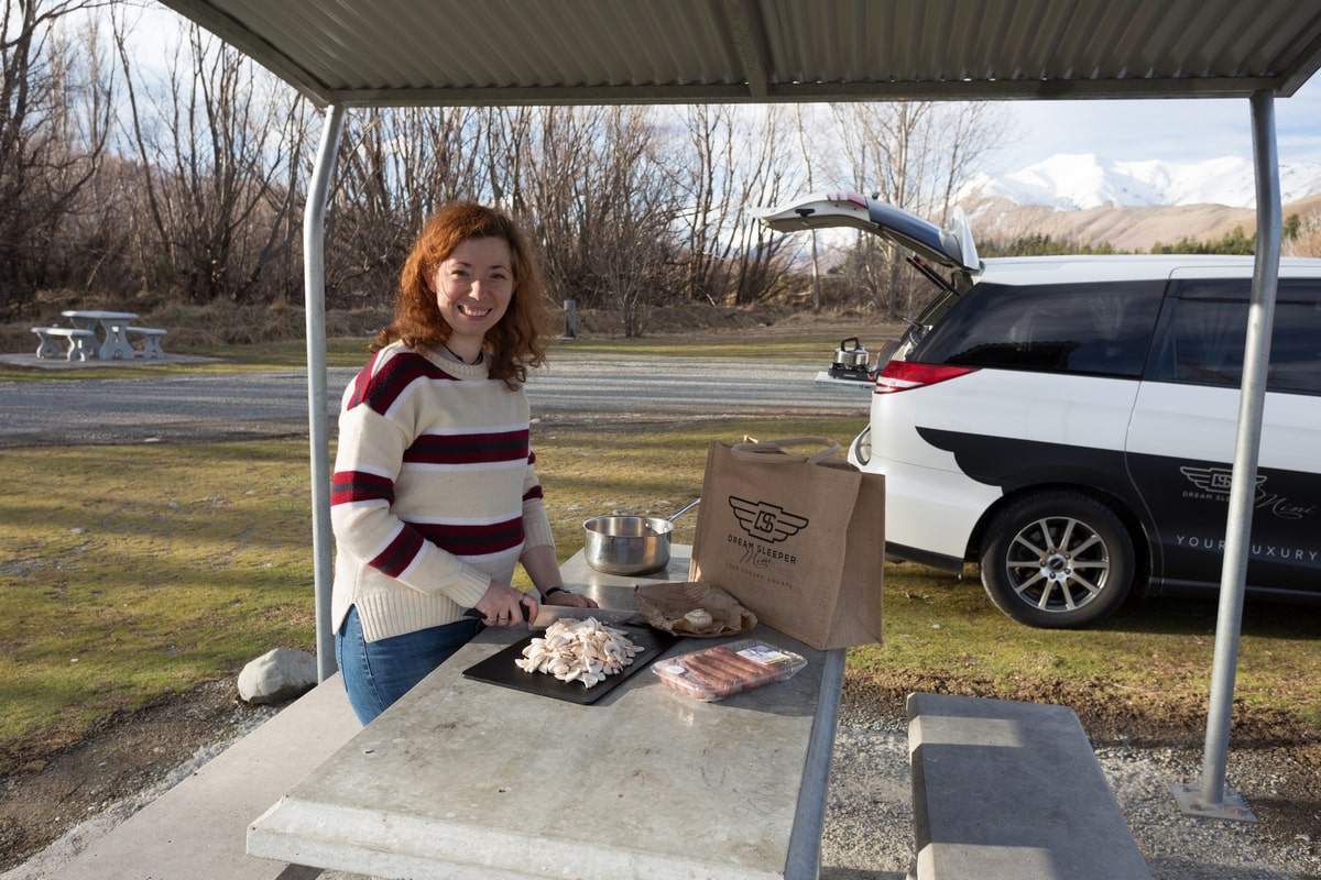 Making food at a free campsite while travelling through New Zealand in a campervan in winter.