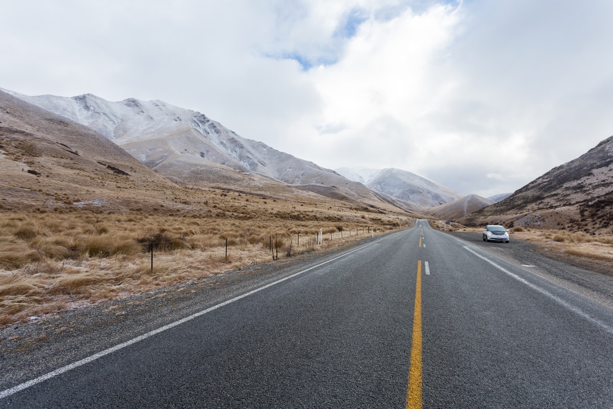 New Zealand South Island road with non self-contained van parked on the side.