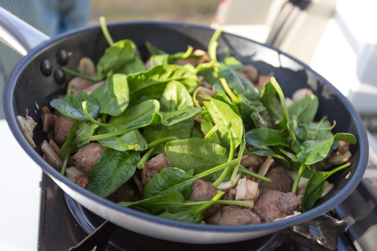 Camping food one pan meal sausage balls and spinach.