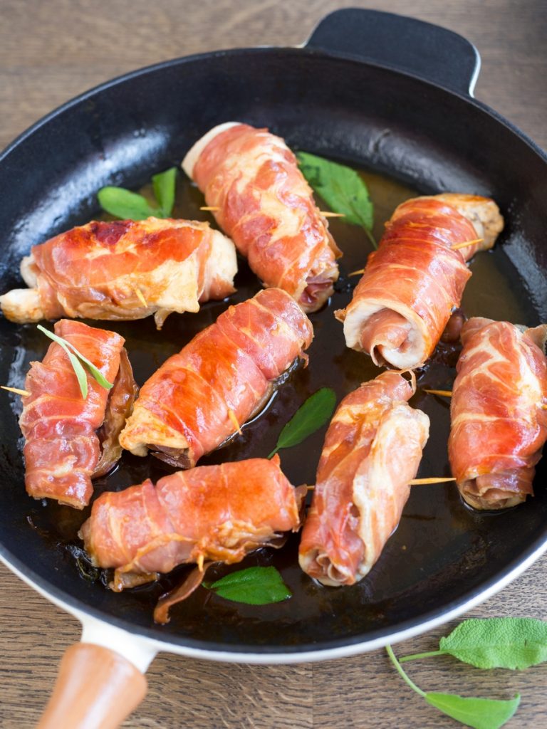 Chicken involtini rolled in prosciutto, cooked in sage butter and white wine in a skillet.