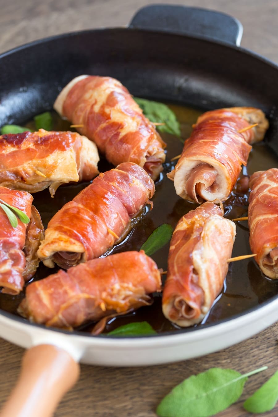 Prosciutto chicken involtini ready to eat served in cast iron skillet.