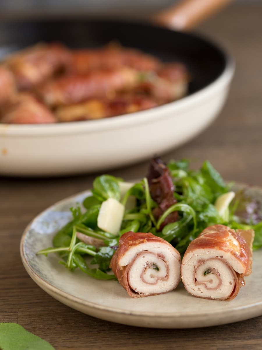 Plated sliced chicken involtini with green salad.