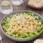 Curry chicken and pineapple salad in a bowl with two glasses of drink.