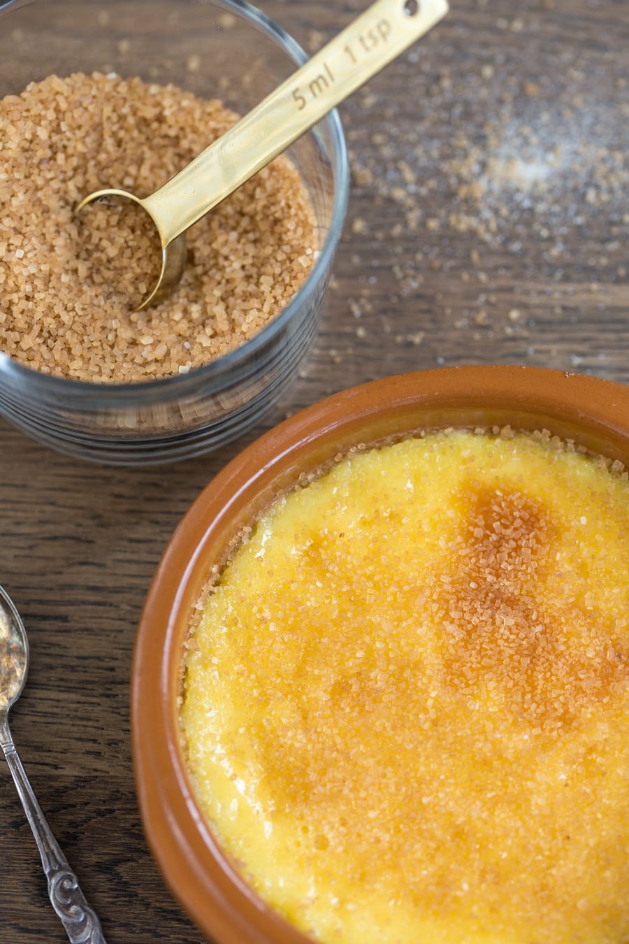 Cane sugar sprinkled over crème brûlée.