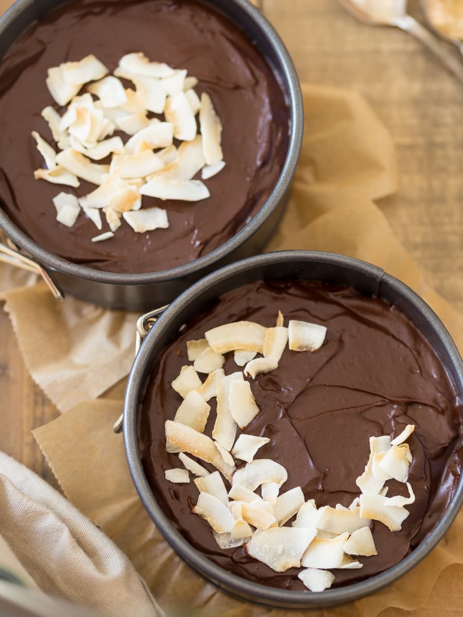 Close up of 2 small chocolate cakes with date syrup in two springform pans.