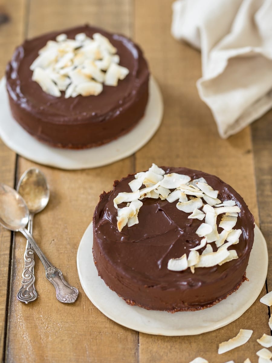 Two small vegan fudge cakes on wooden table.
