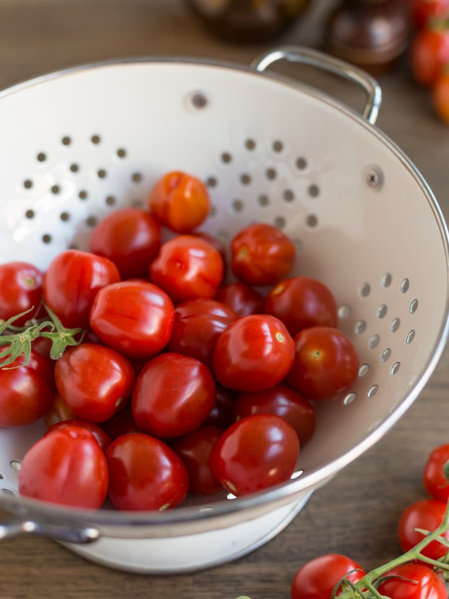 Cherry tomatoes in a white colander.