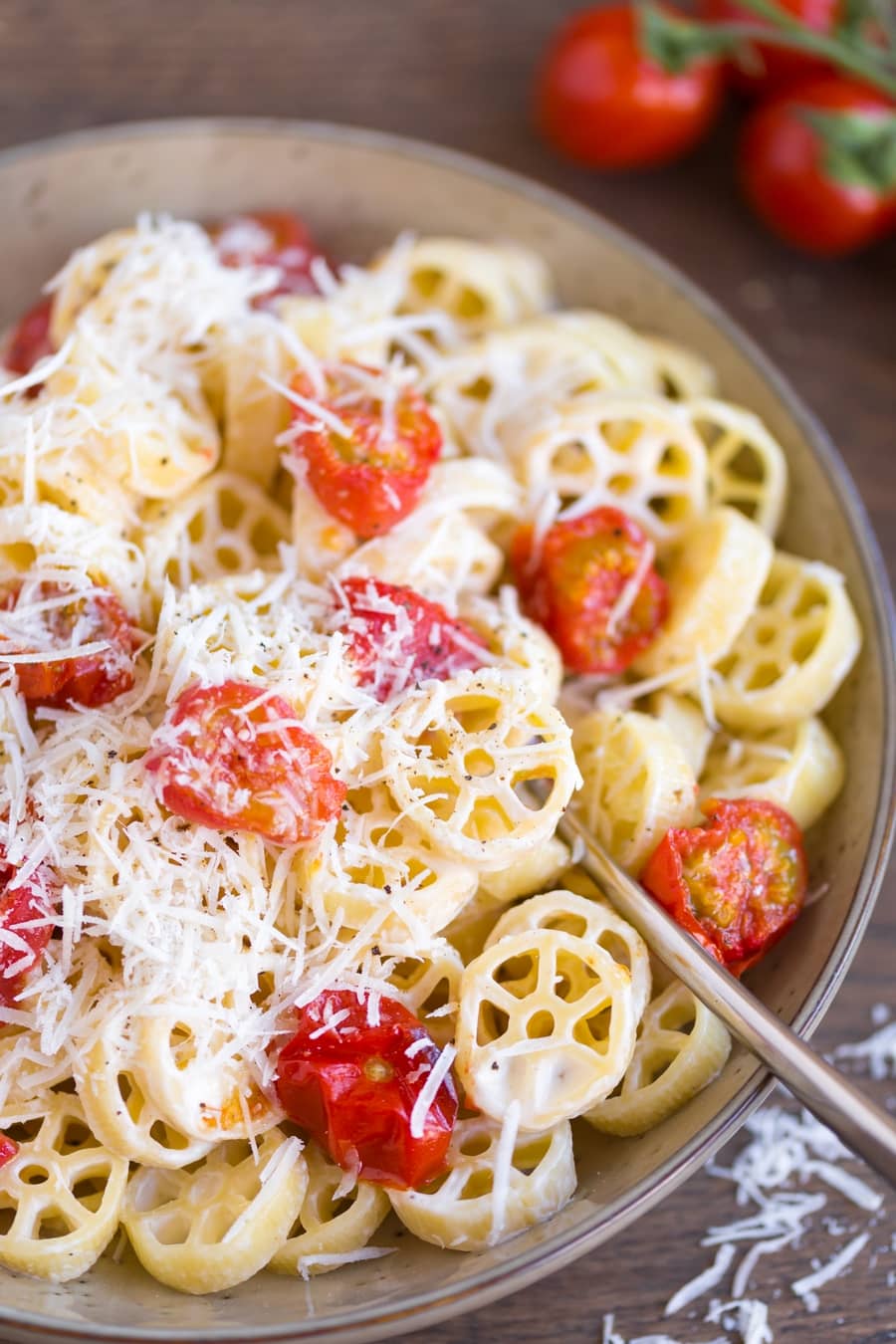 Creamy pasta with overn-roasted cherry tomatoes closeup.