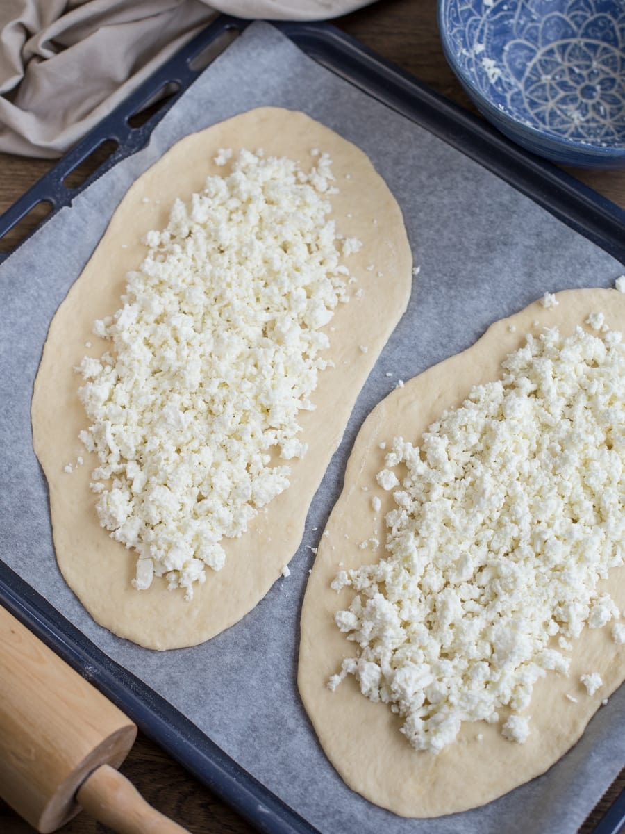 Sourdough khachapuri dough rolled out and filled with cheese mixture.