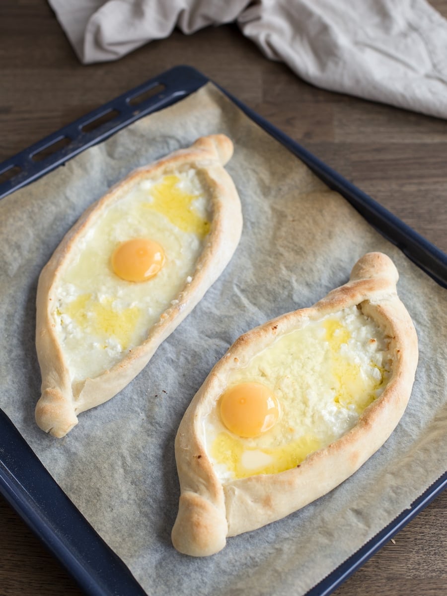 Homemade sourdough khachapuri adjaruli with cheese and egg.