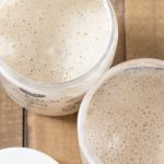 Open plastic jars showing sourdough starter inside.