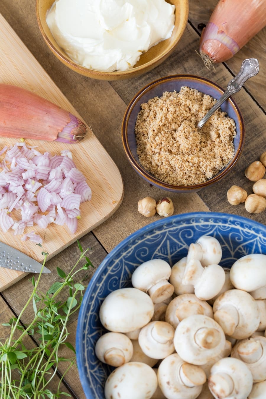Flatlay image of ingredients needed for the preparation of stuffed mushroom caps.
