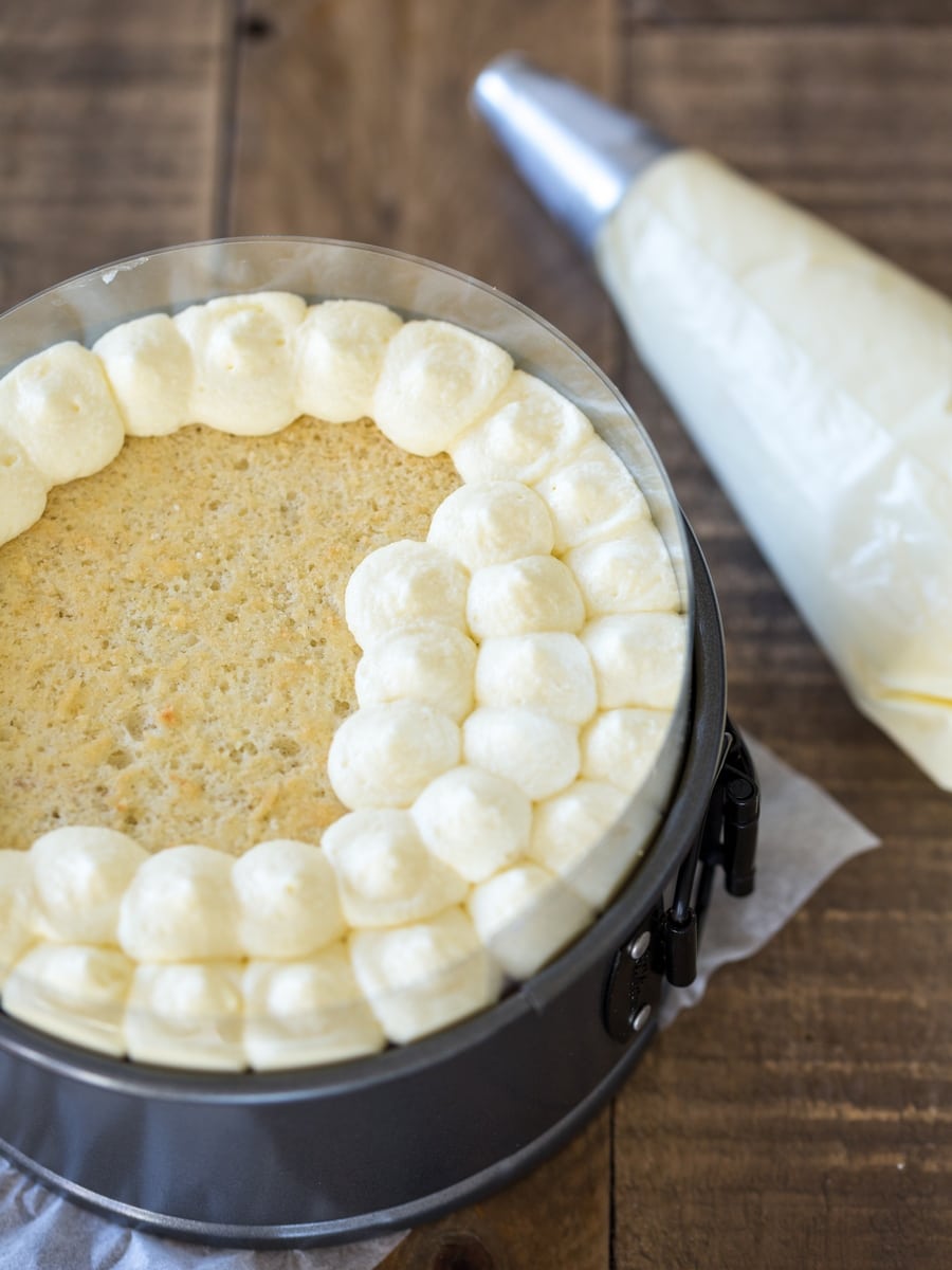 Piping top layer of tiramisu cake.
