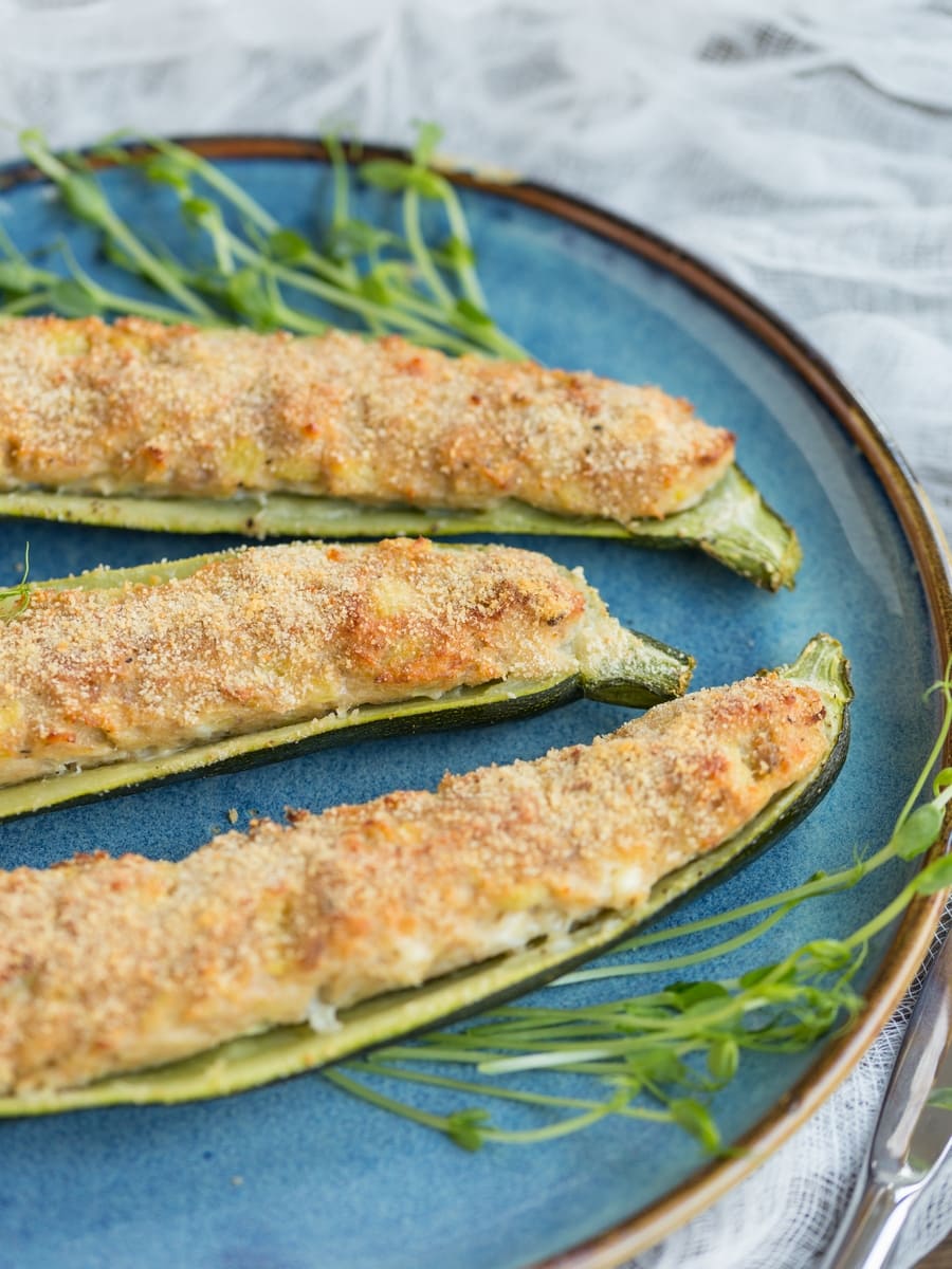 Tuna zucchini boats served on a blue plate.