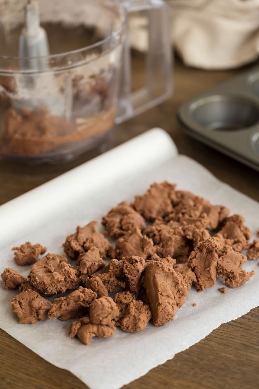 Chocolate shortcrust crumbs over parchment paper.
