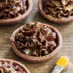 Mascarpone chocolate cream tarts decorated with gold glitter.