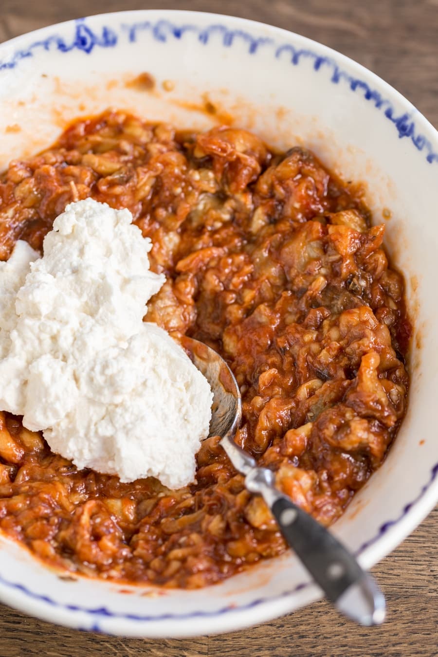 Mashed eggplants with tomato and chili oil; ricotta added to the side.