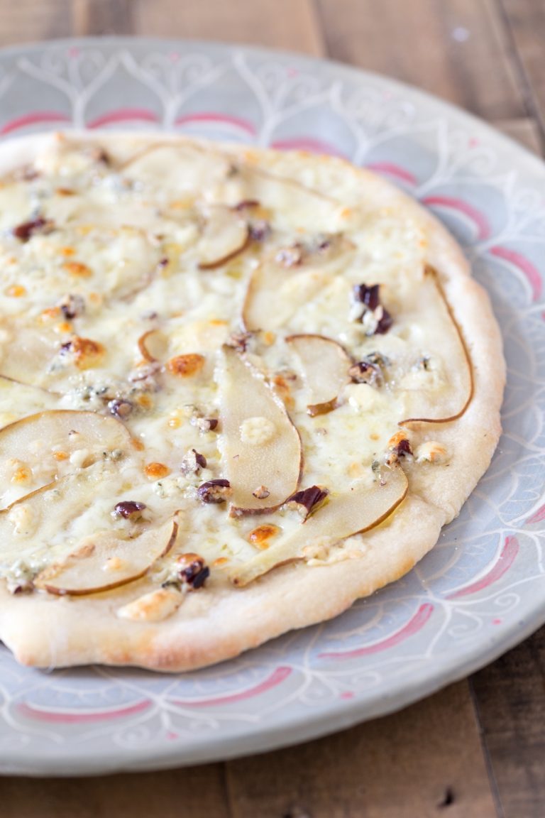 Pear and blue cheese pizza on nice serving plate.
