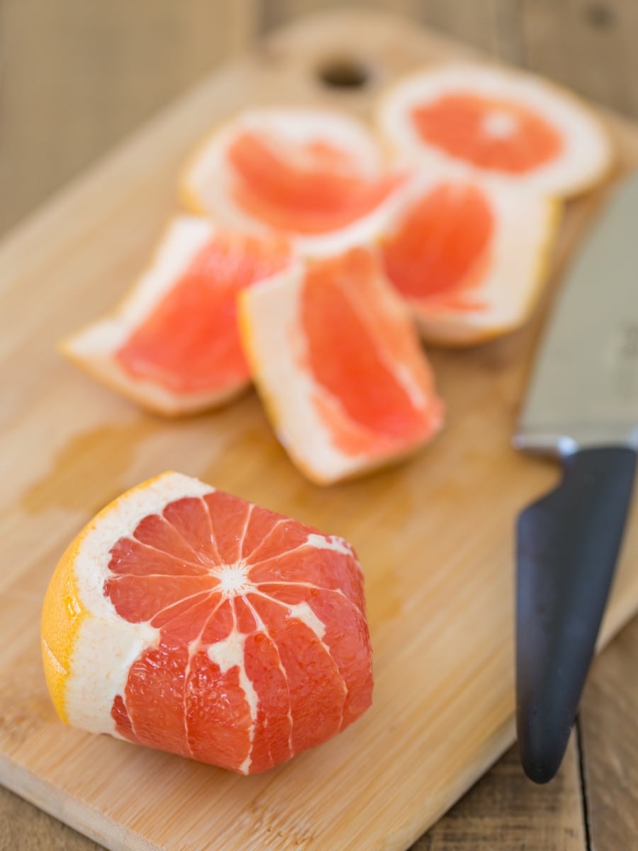 Grapefruit being peeled witha knife.