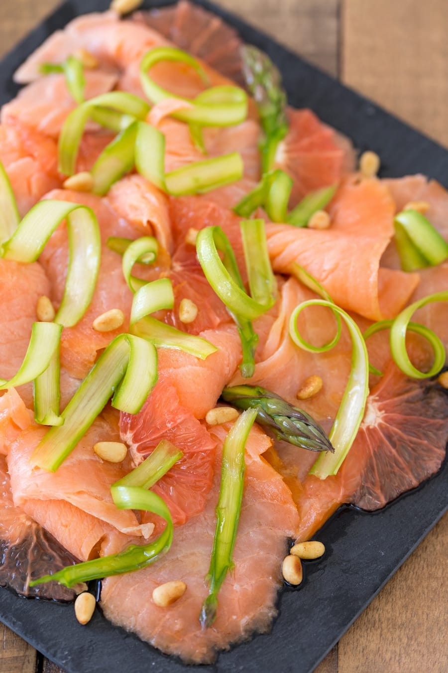 Raw asparagus salmon carpaccio with thinly sliced red grapefruit.