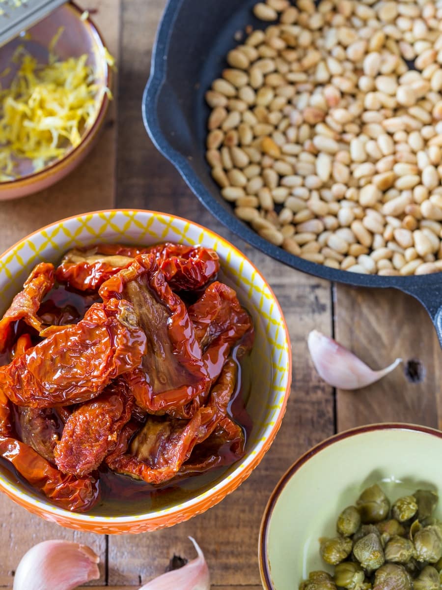 Sun-dried tomatoes in oil, toasted pine nuts in a skillet, capers, lemon zest and three garlic cloves.
