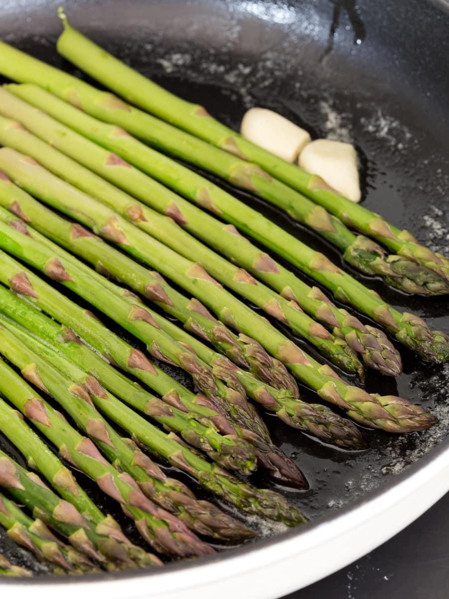 Green asparagus sautéed in cast iron skillet.