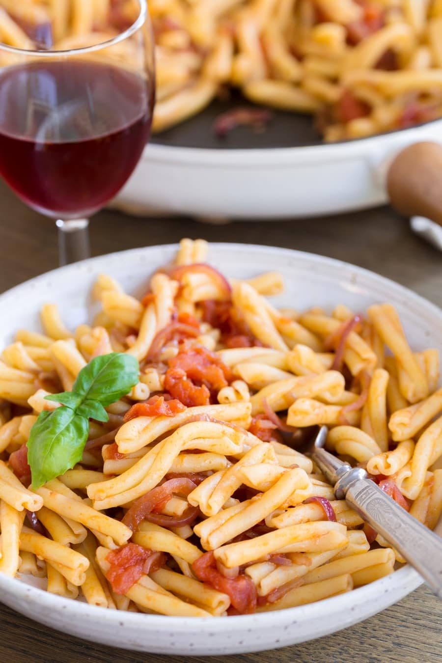Balsamico onion pasta with fresh tomato sauce in a bowl.