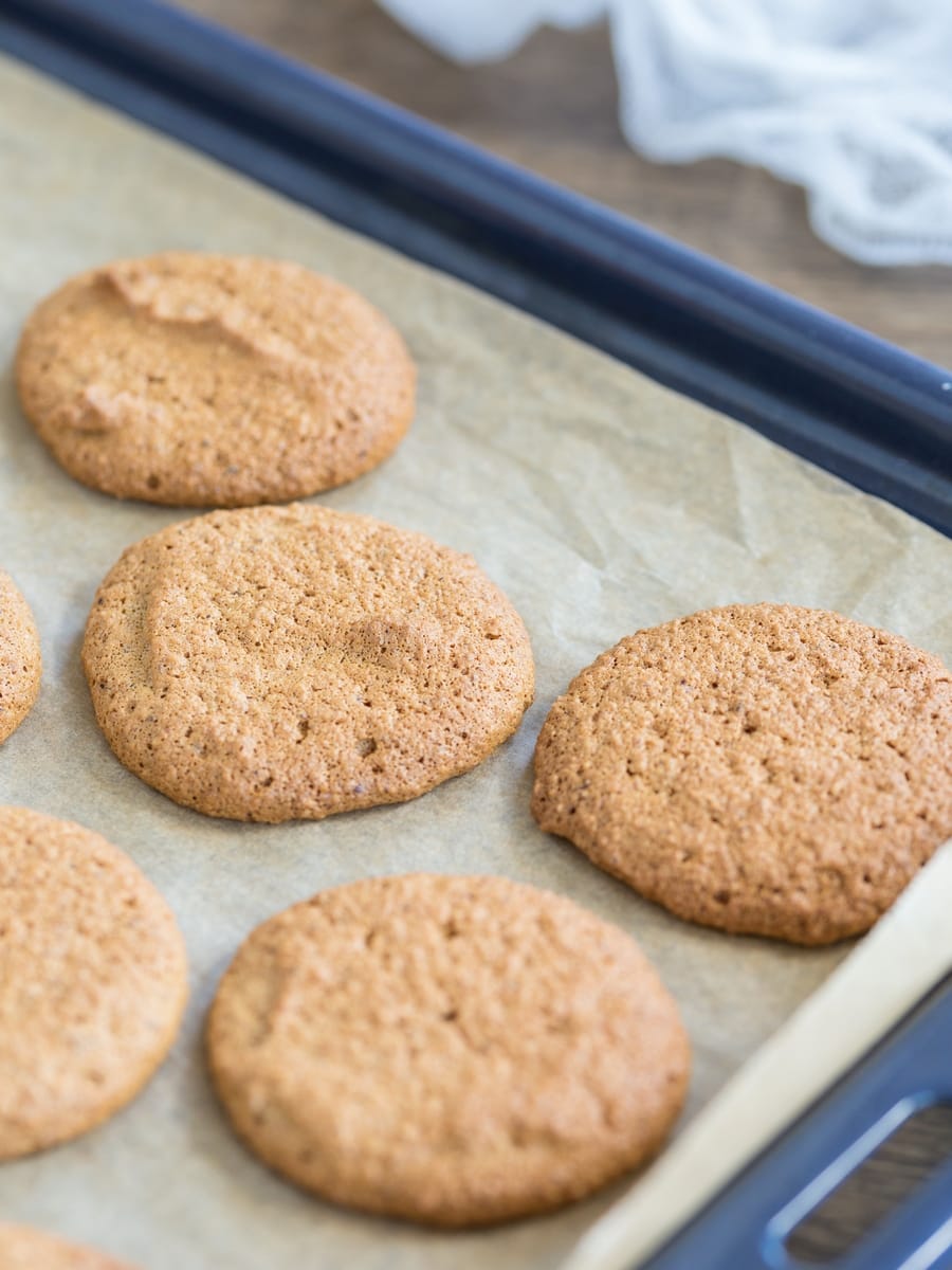 Honey hazelnut meringue cookies on a sheet pan.