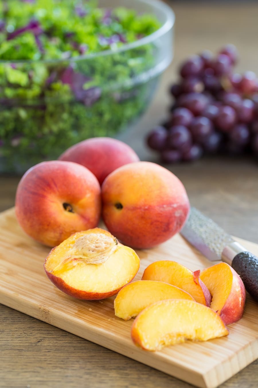 Fresh peaches on a cutting board.