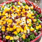 Fruity kale salad with peaches, grapes and almonds. With vegan balsamico dressing.