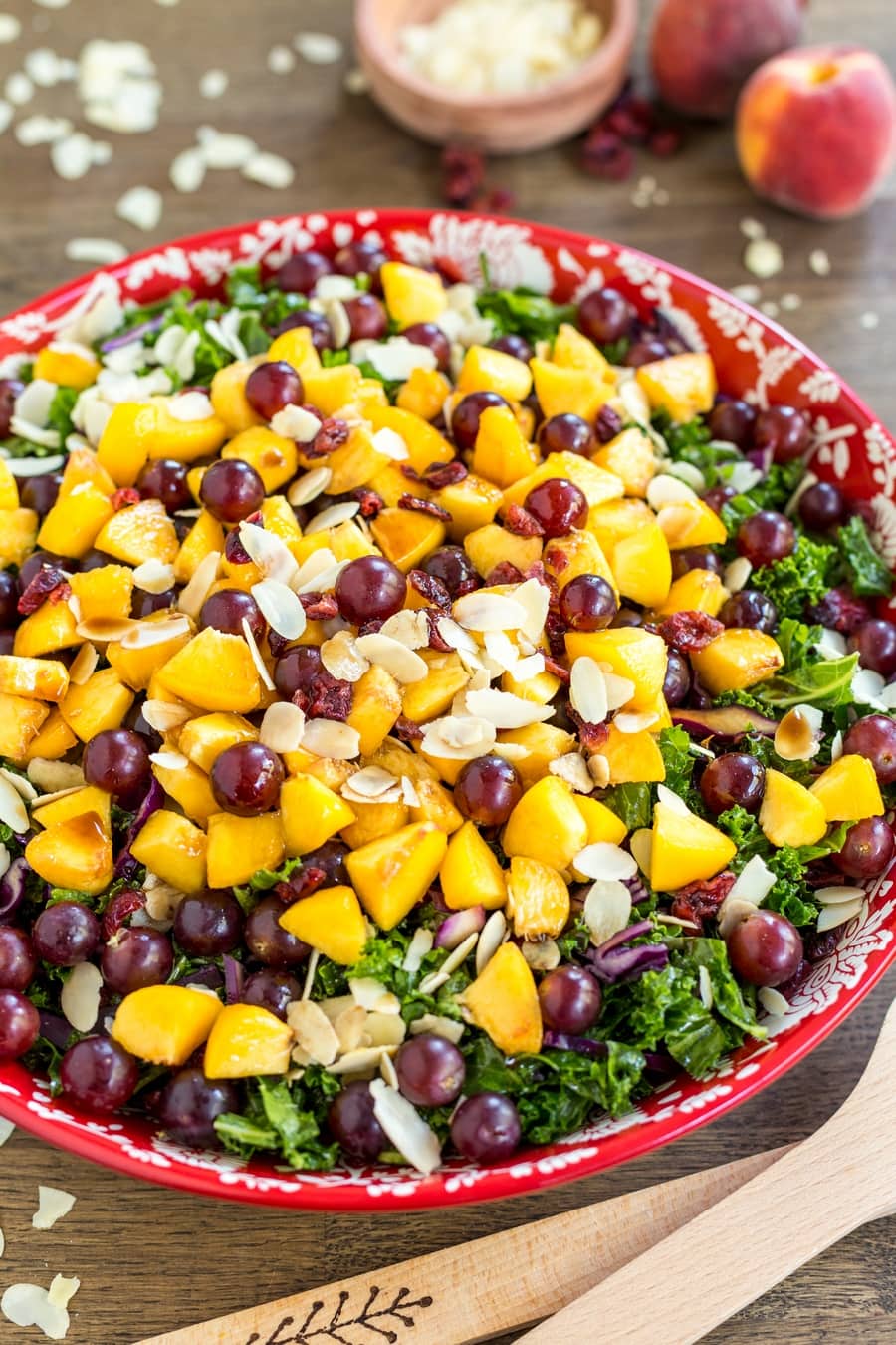 Fruity kale salad with peaches, grapes and almonds. With vegan balsamico dressing.