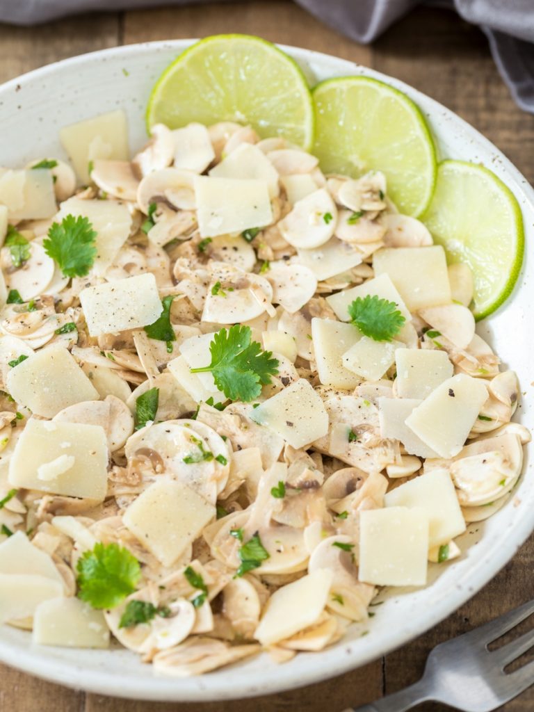 Raw mushroom salad made with cultivated mushrooms, lime, cilantro and parmigiano flakes.