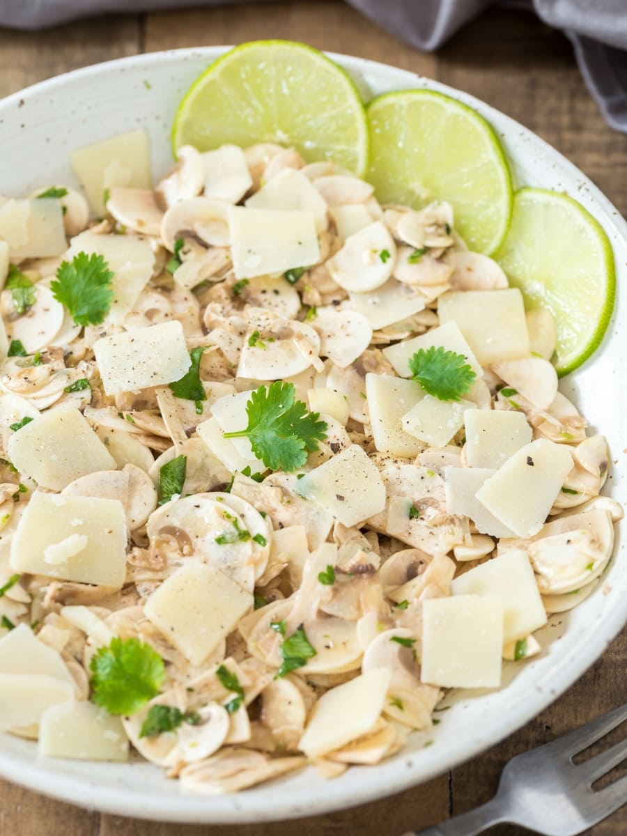 Insalata di funghi crudi a base di funghi coltivati, lime, coriandolo e scaglie di parmigiano.