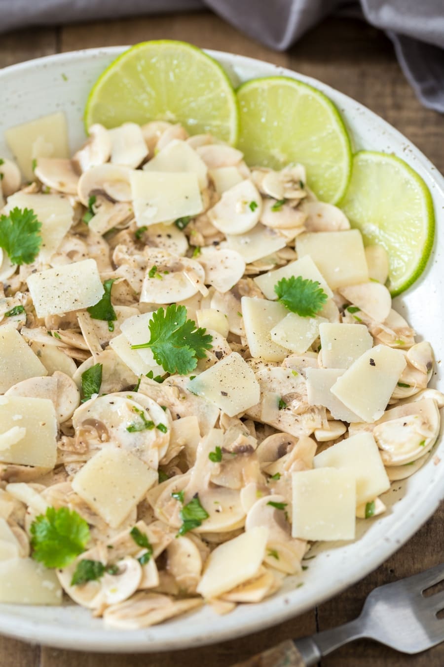 Insalata di funghi crudi con lime, coriandolo e scaglie di parmigiano.
