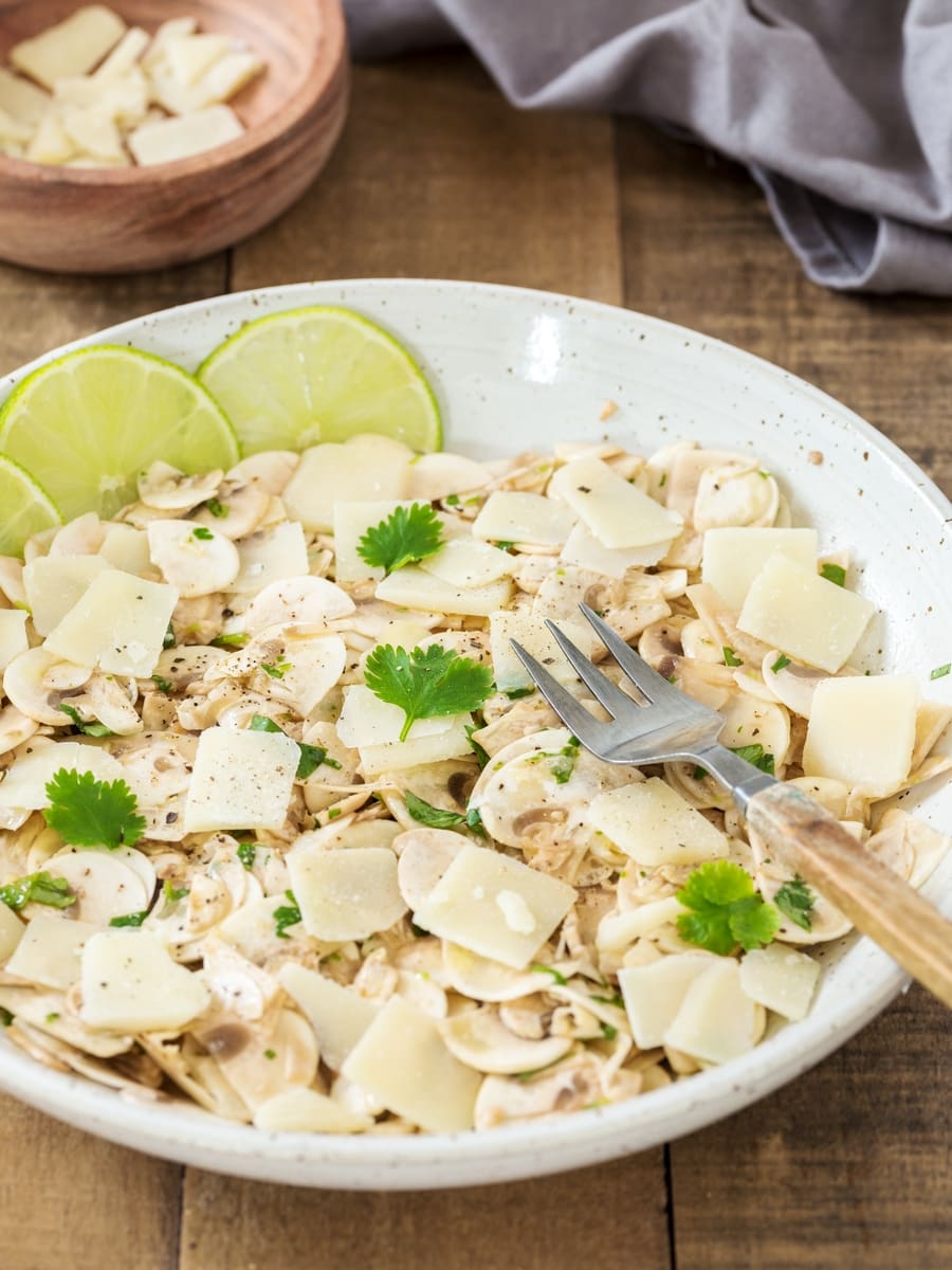 Insalata di funghi crudi al coriandolo e lime con scaglie di parmigiano.